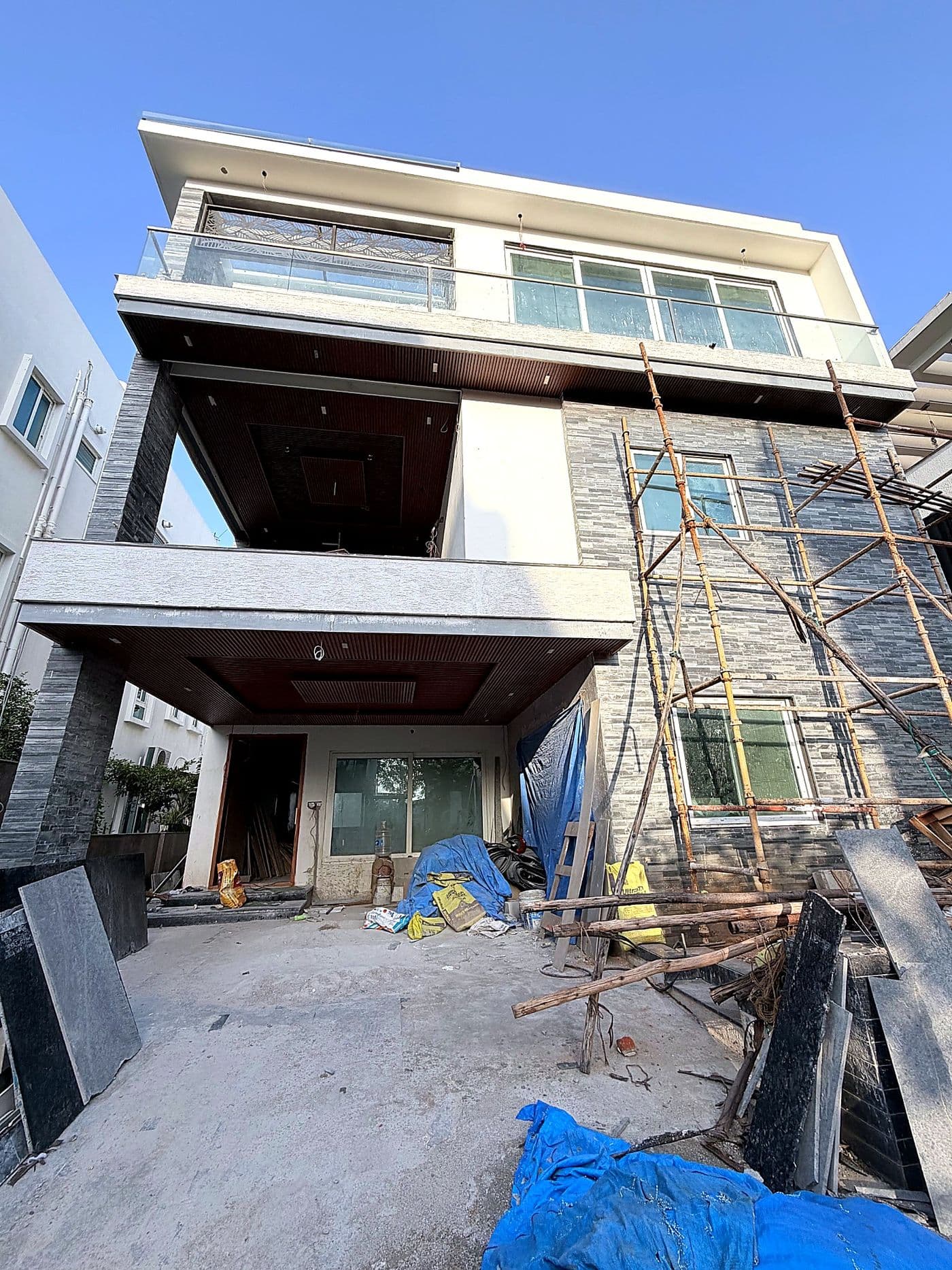 Villa under construction with scaffolding, seen from the front